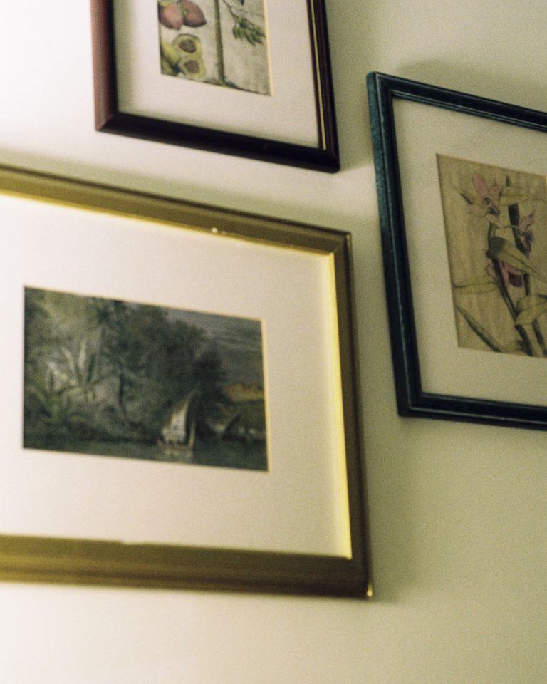Framed pictures hung on a wall using damage-free adhesive strips instead of nails